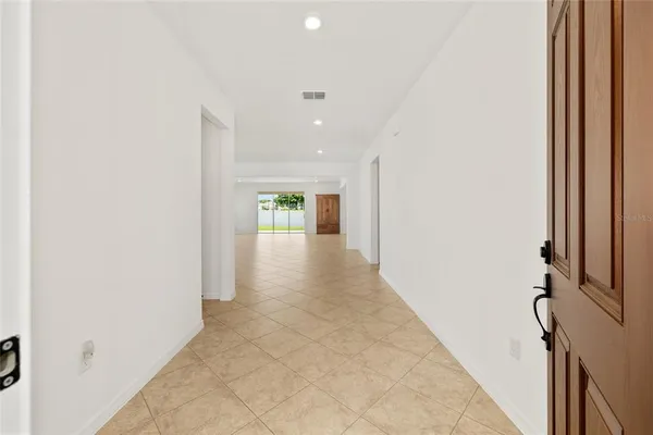 a view of an empty room with wooden floor and windows