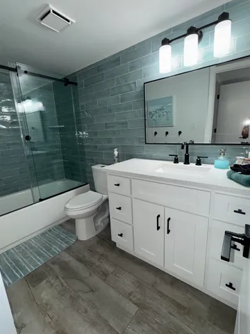 a spacious bathroom with a double vanity sink a toilet and a mirror
