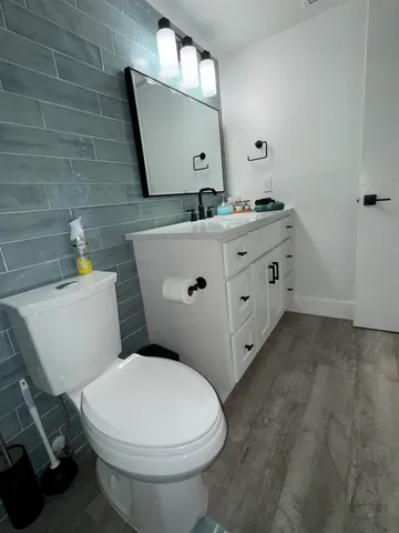 a bathroom with a toilet sink and mirror