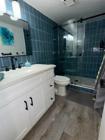 a bathroom with a sink a toilet and shower