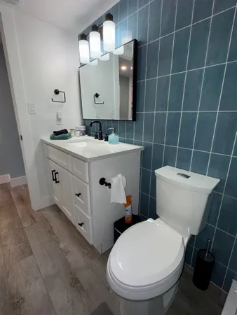 a bathroom with a toilet a sink and mirror