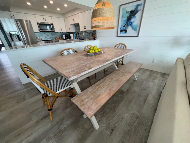 a living room with stainless steel appliances furniture rug and a kitchen view
