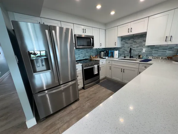 a kitchen with stainless steel appliances granite countertop a refrigerator stove and sink