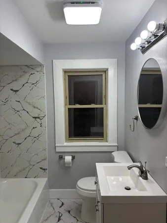 a bathroom with a toilet sink and mirror