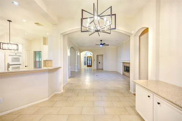 a view of a livingroom with a chandelier and kitchen view