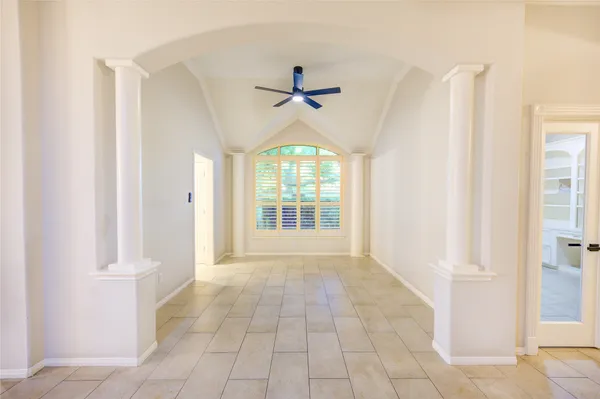 an empty room with fireplace and windows