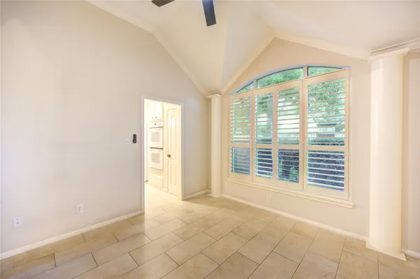 a view of an empty room with a window and a kitchen