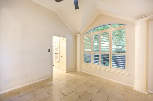 a view of an empty room with a window and a kitchen