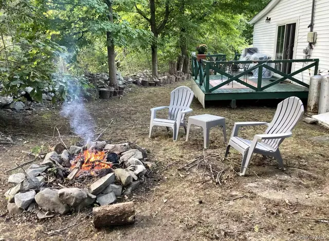 a view of a backyard with table and chairs and a fire pit