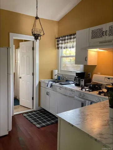 a kitchen with a refrigerator a stove a sink and a window