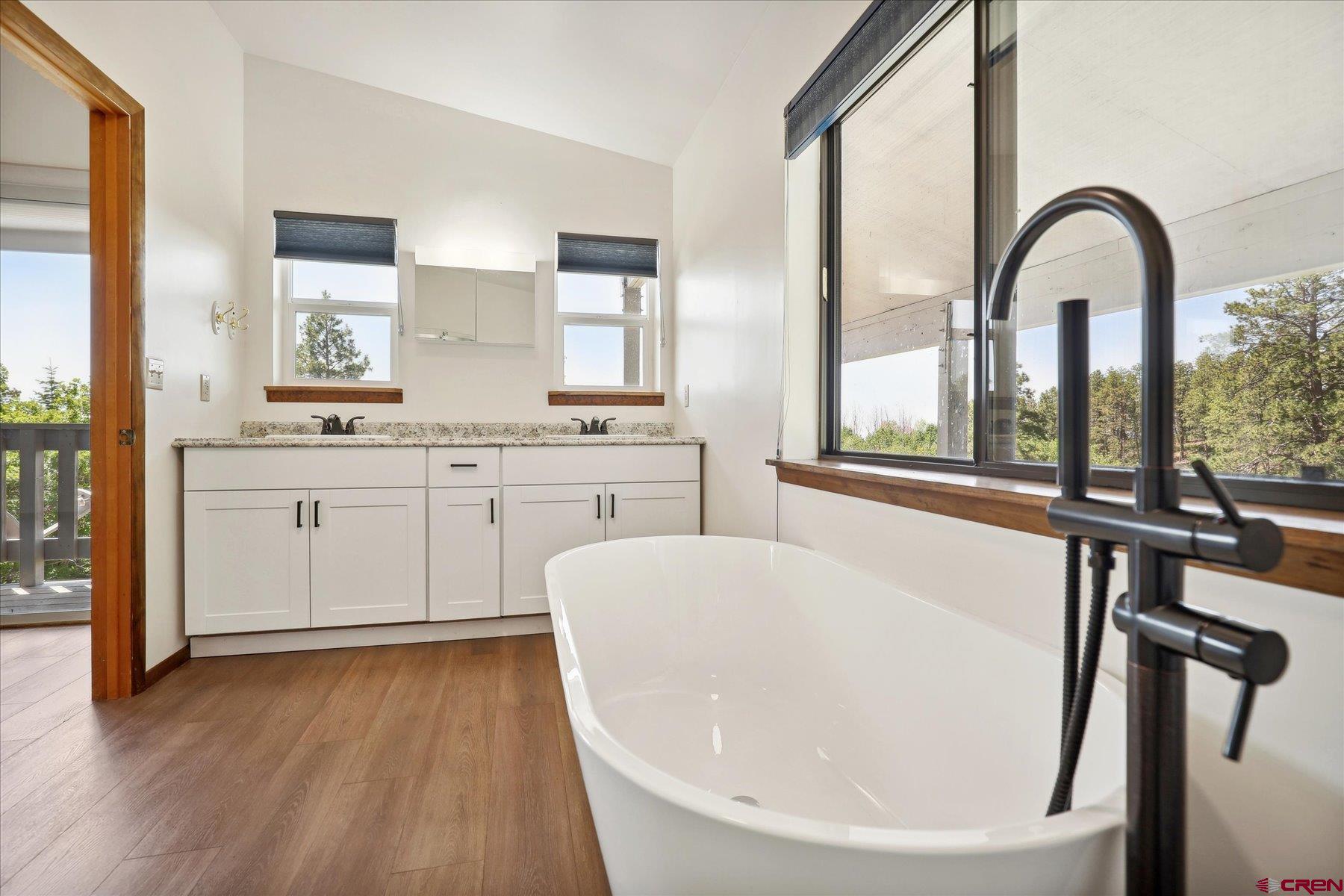 1039 Silver Mesa Driveway Durango, CO 81301 - Photo 12 of 35 a en suite bathroom with a granite countertop sink a mirror and a bathtub
