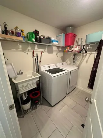 a utility room with dryer washer and shoe rack