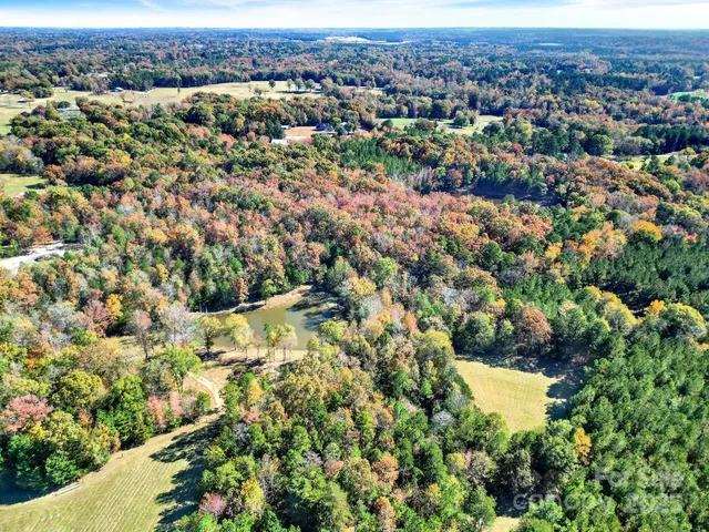 an aerial view of residential houses with outdoor space and trees