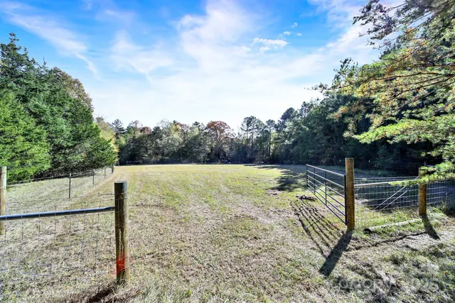 a view of a yard with wooden fence