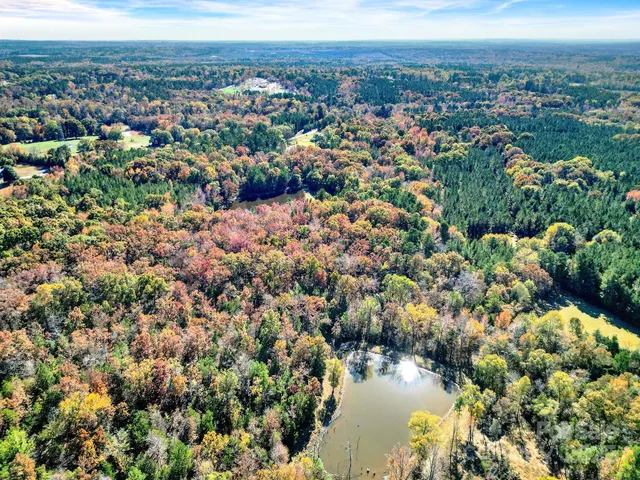 an aerial view of residential houses with outdoor space and trees