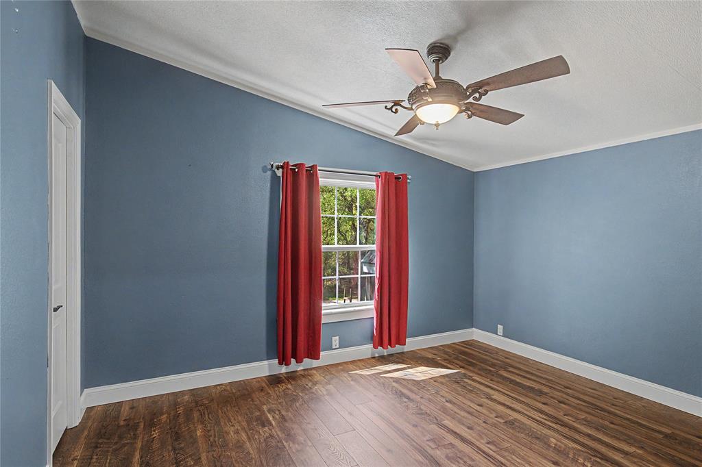 1701 Central Road Weatherford, TX 76088 - Photo 26 of 40 Bedroom featuring dark wood-type flooring, ceiling fan, and ornamental molding.
