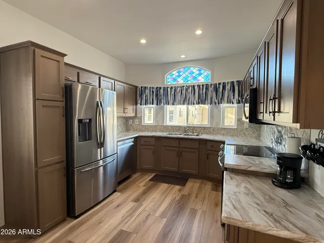 a kitchen with granite countertop stainless steel appliances a refrigerator and counter space