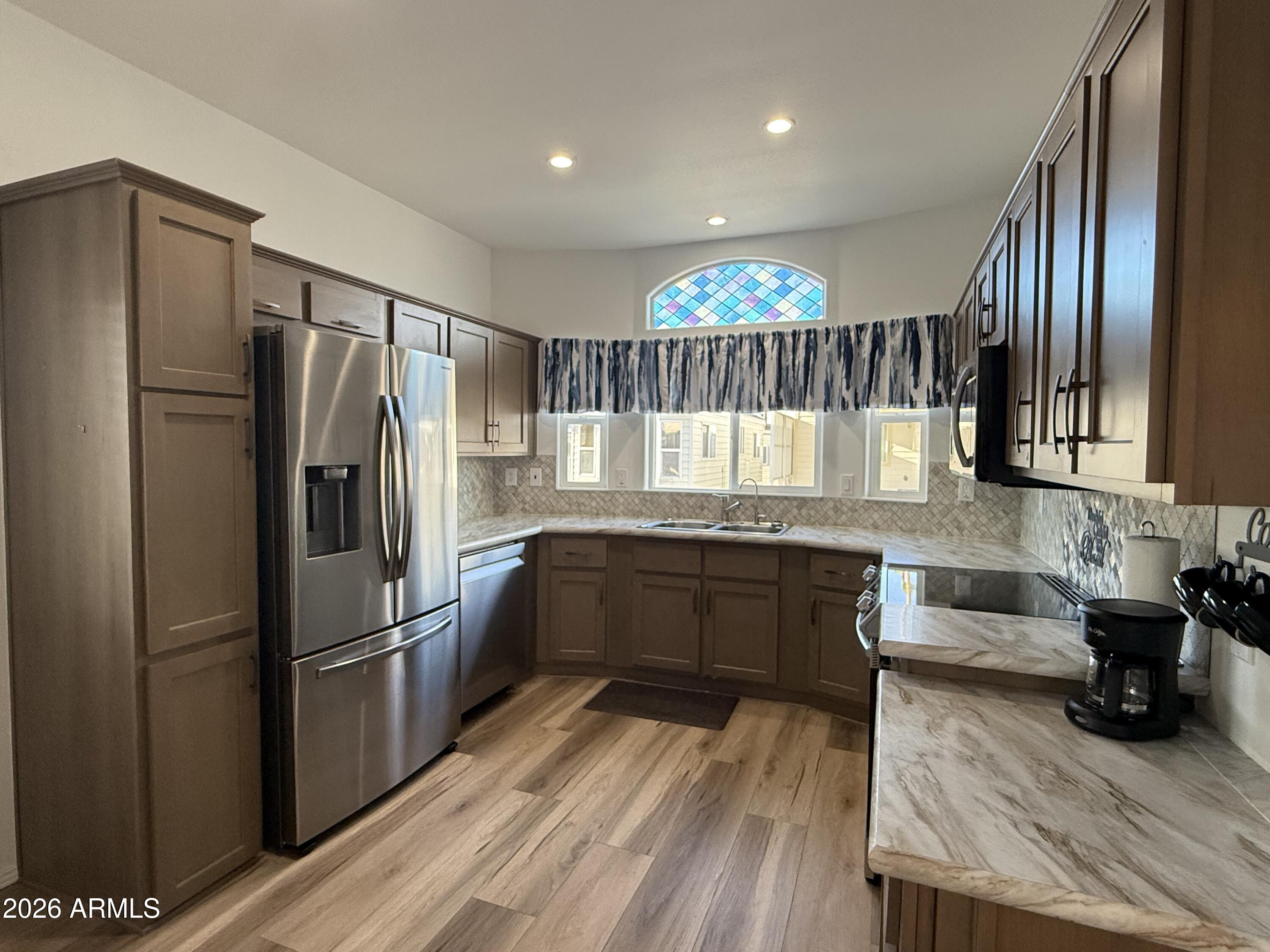 744 Emerald Drive Apache Junction, AZ 85119 - Photo 5 of 25 a kitchen with granite countertop stainless steel appliances a refrigerator and counter space