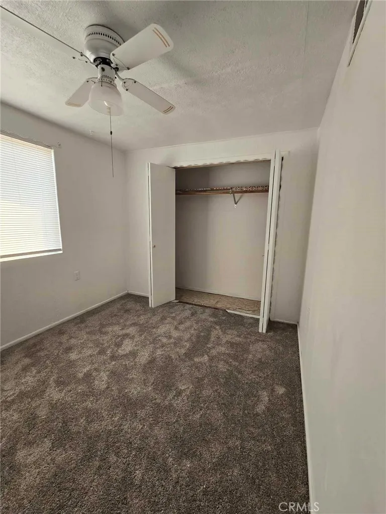 36614 Leona Road Barstow, CA 92311 - Photo 12 of 24 an empty room with a chandelier fan and entryway