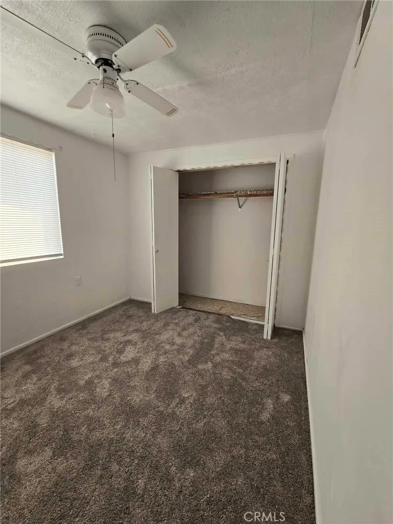 36614 Leona Road Barstow, CA 92311 - Photo 12 of 24 an empty room with a chandelier fan and entryway