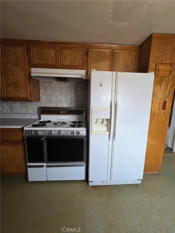 an empty room with a chandelier fan and entryway