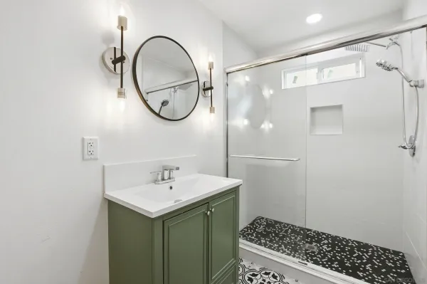 a bathroom with a sink a mirror and a shower