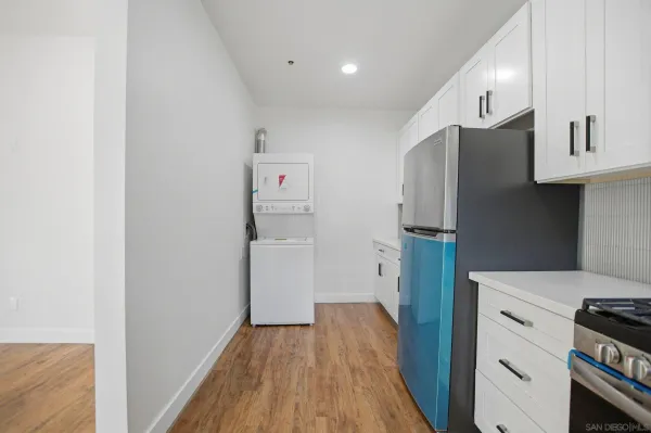 a kitchen with a refrigerator a stove and wooden floor