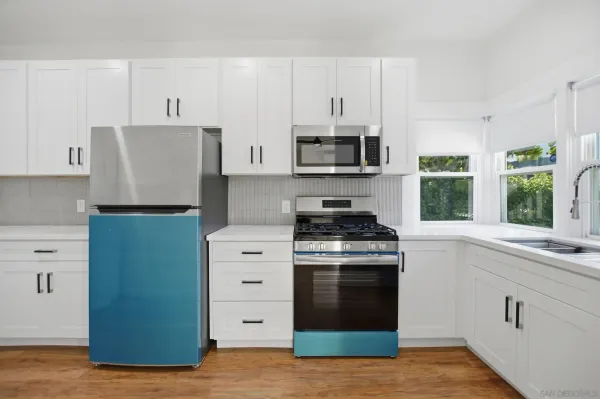 a kitchen with stainless steel appliances granite countertop a stove a refrigerator and a sink