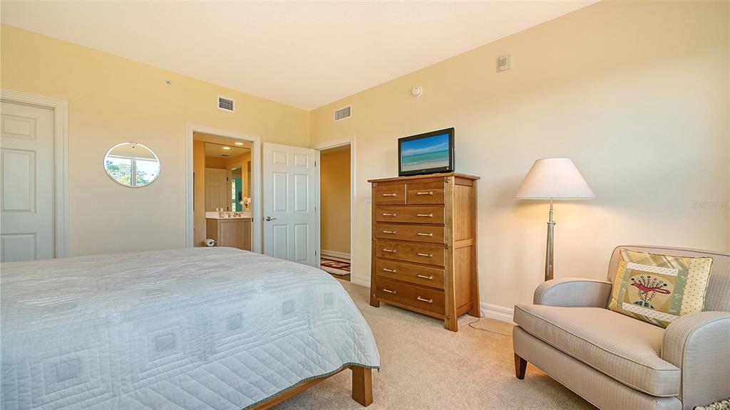 3621 North Point Road, Unit 301 Osprey, FL 34229 - Photo 40 of 95 a spacious bedroom with a bed and a lamp