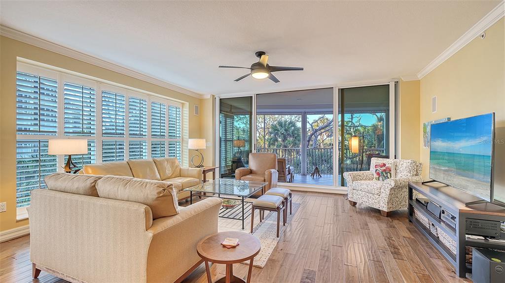 3621 North Point Road, Unit 301 Osprey, FL 34229 - Photo 8 of 95 a living room with furniture tv and wooden floor