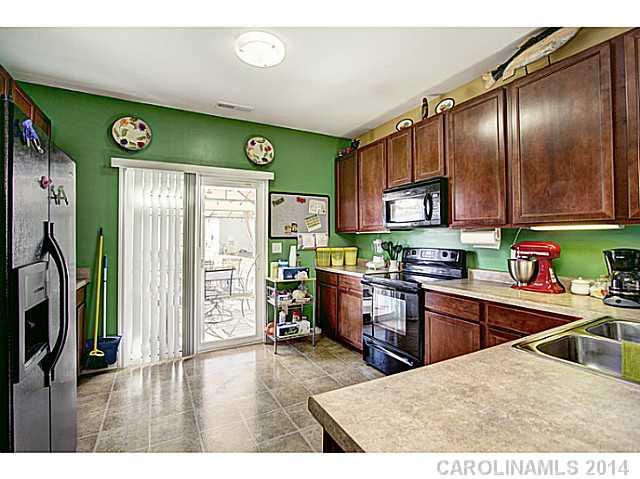 9223 Yellow Oak Road Charlotte, NC 28227 - Photo 5 of 15 a kitchen with stainless steel appliances granite countertop a refrigerator a sink dishwasher a stove and white cabinets with wooden floor
