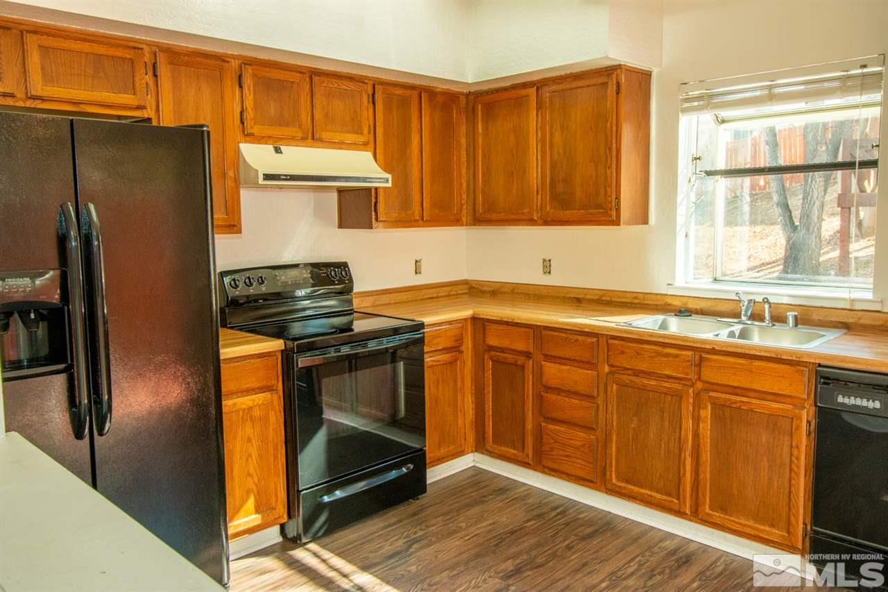 6480 Enchanted Valley Drive Reno, NV 89523 - Photo 3 of 12 a kitchen with stainless steel appliances granite countertop a refrigerator stove and sink