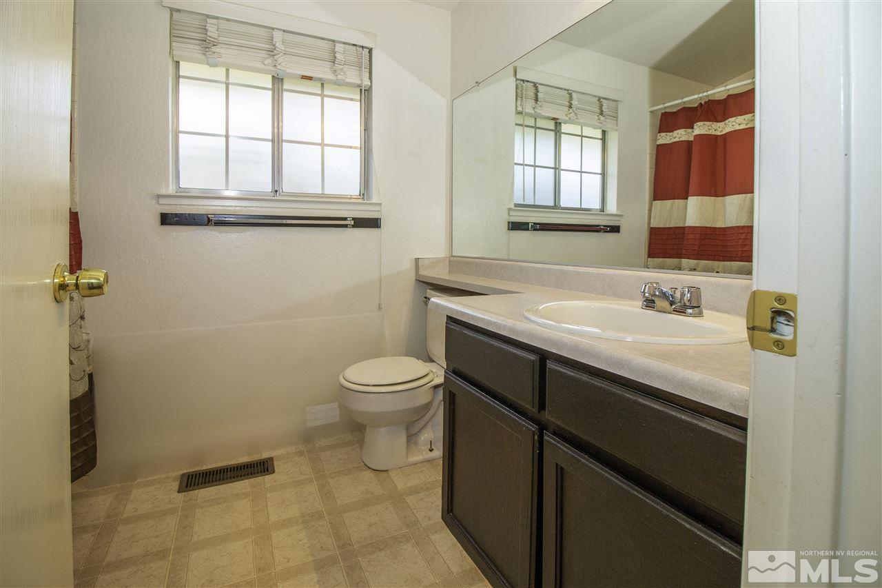 6480 Enchanted Valley Drive Reno, NV 89523 - Photo 10 of 12 a bathroom with a sink a toilet and window