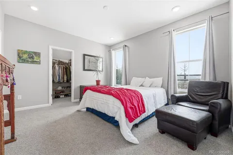 a spacious bedroom with a bed and glass window