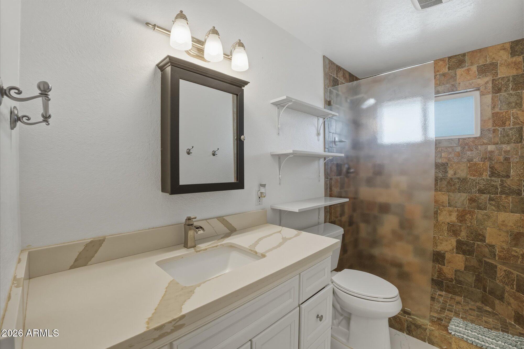 1532 West Loma Lane Phoenix, AZ 85021 - Photo 14 of 19 a bathroom with a sink toilet and shower