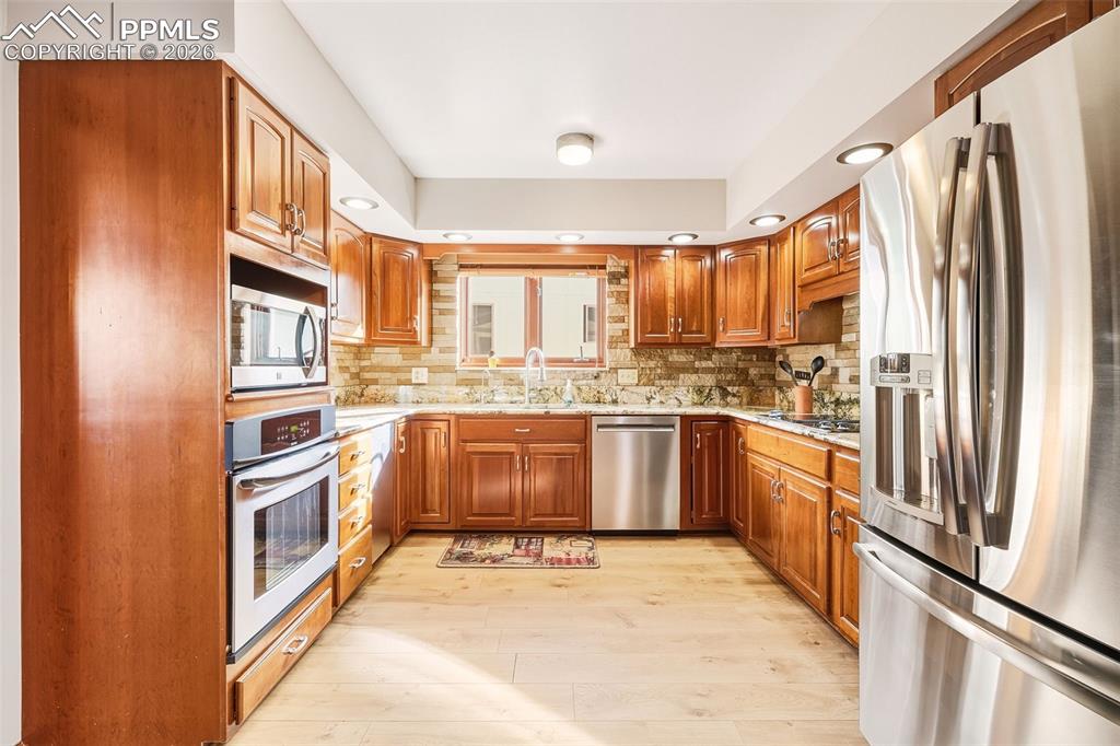 2771 Rigel Drive Colorado Springs, CO 80906 - Photo 11 of 50 Thoughtfully designed workspace with ample counter space, double sink beneath a window, and direct connection to the dining area for easy entertaining.