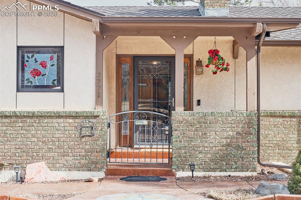 2771 Rigel Drive Colorado Springs, CO 80906 - Photo 2 of 50 Covered front entry with decorative glass door, brick accents, and welcoming curb appeal.