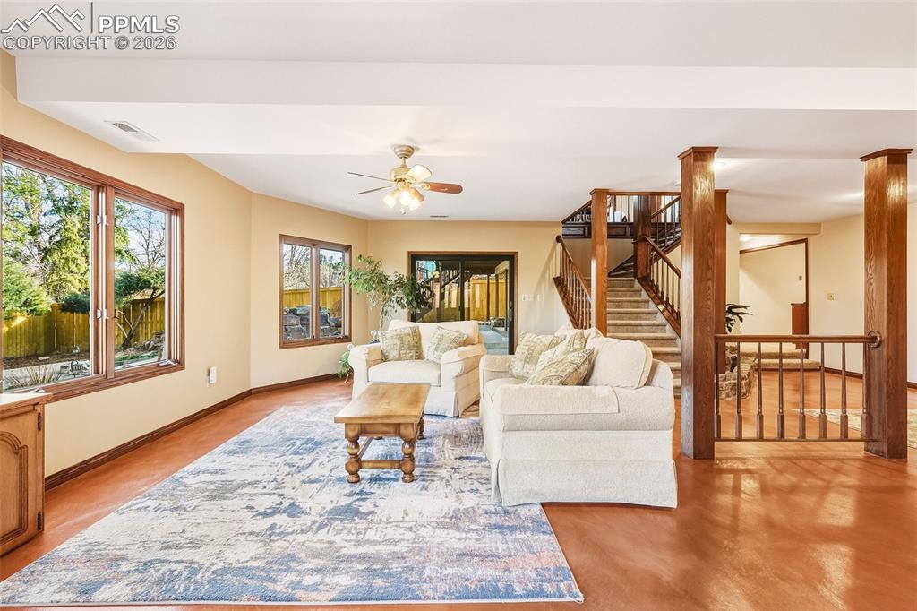2771 Rigel Drive Colorado Springs, CO 80906 - Photo 30 of 50 Basement Family Room – Reverse View – Expansive layout connecting the family room to the staircase and outdoor access, offering flexible space for recreation or relaxation.