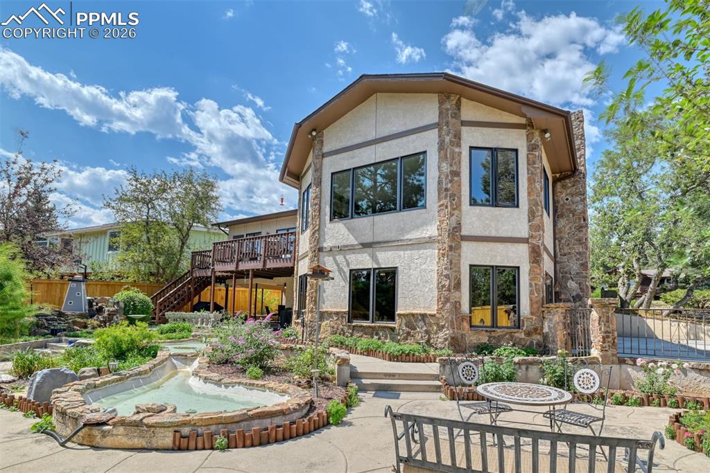 2771 Rigel Drive Colorado Springs, CO 80906 - Photo 39 of 50 Beautifully landscaped yard with winding walkways, water features, and mature trees, all enclosed by upgraded fencing for added privacy.