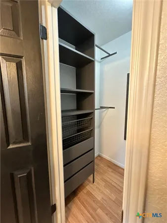 a view of walk in closet with empty racks