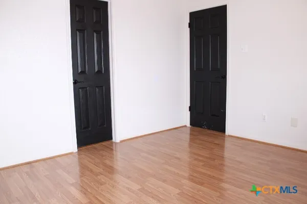 an empty room with wooden floor and closet