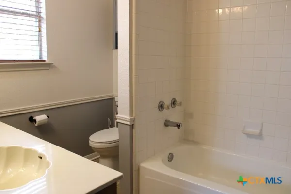 a bathroom with a sink a toilet and bathtub