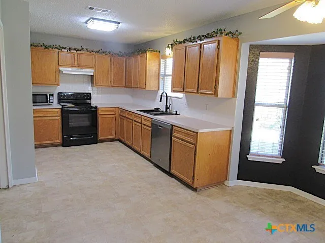a kitchen with stainless steel appliances granite countertop a stove a sink and a microwave