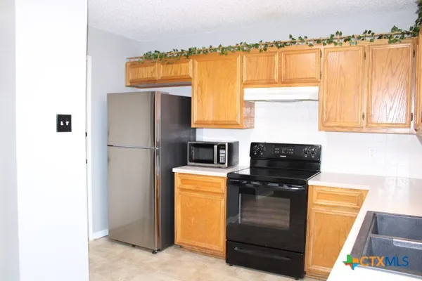 a kitchen with a refrigerator and a stove