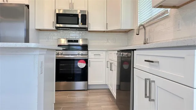 a kitchen with stainless steel appliances granite countertop a stove and a refrigerator