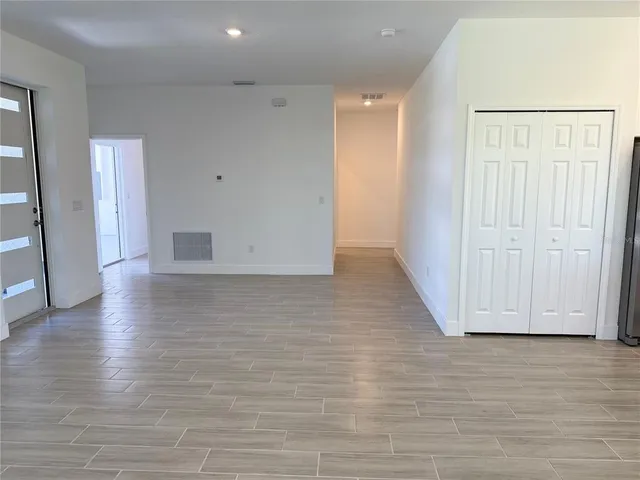 a view of empty room with wooden floor