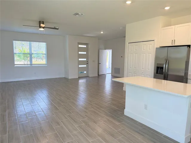 a view of a kitchen with wooden floor and a refrigerator