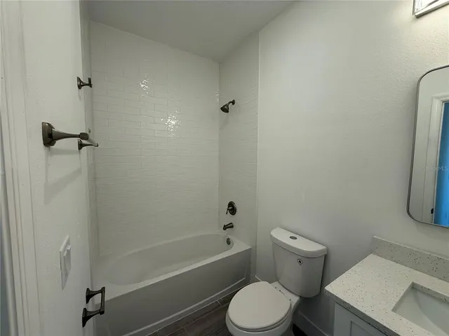 a white toilet sitting next to a bath tub