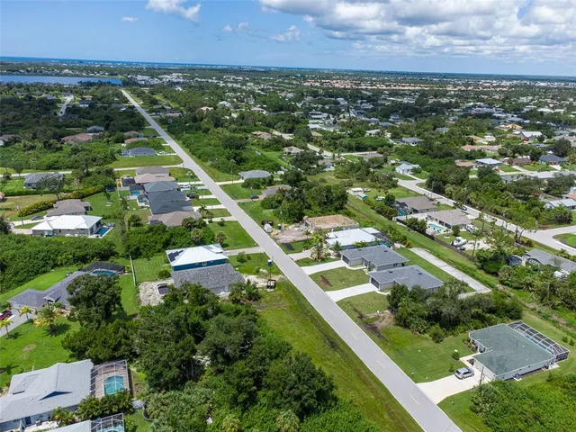 an aerial view of residential houses with outdoor space and a lake view