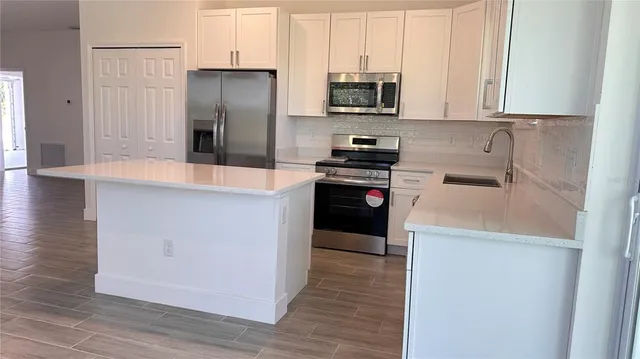 a kitchen with stainless steel appliances granite countertop a refrigerator stove and sink